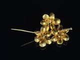 a gold flower brooch on a black background