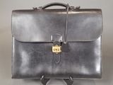 leather briefcase with a lock on the front of it on a gray background