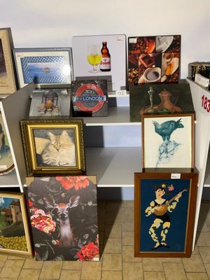 de nombreuses photos et peintures posées sur une étagère dans une pièce