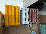 many plastic crates stacked on a shelf in a kitchen