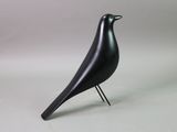 a black bird that is standing on a metal stand