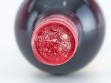 a close up of a bottle of wine with a red cap