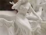 a statue of a woman riding a boat on a table