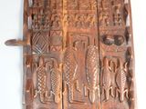 sculptures sur le mur d'une vieille porte en bois munie d'une poignée