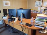 a desk with two computer monitors and a laptop on it