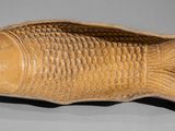 une image représentant un objet en bois en forme de poisson posé sur une table