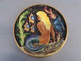 une photo d'une assiette décorative sur laquelle figure une sirène