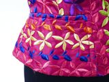 a close up of a woman ' s pink top with colorful flowers on it