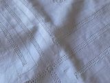 a close up of a white blanket with a cross on it