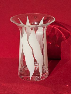 un vase en verre orné d'un motif blanc sur fond rouge