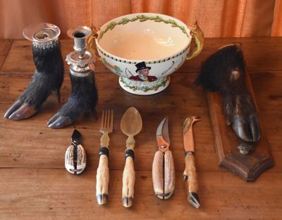 a table with a bowl, knife, spoon, and other items on it
