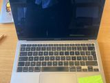 a laptop computer sitting on a desk with a sticky note on it