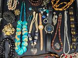 many different types of necklaces and bracelets in this case
