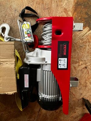 une photo d'un treuil électrique rouge et blanc et d'une boîte à outils