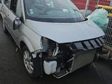 une camionnette blanche endommagée, garée sur le parking