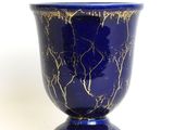 a blue vase with a gold leaf design on it