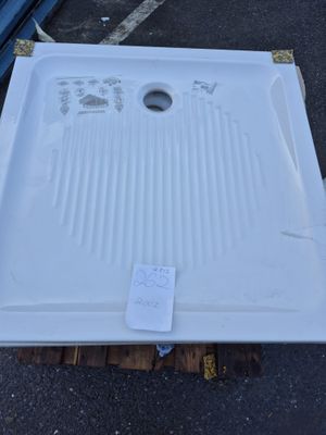 un évier blanc posé sur une palette dans un parking