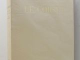a white book with gold lettering sitting on top of a white table