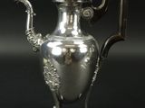 une cafetière ancienne en métal argenté, dotée d'une poignée et d'une autre poignée