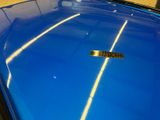 a close up of a blue car with a sticker on it