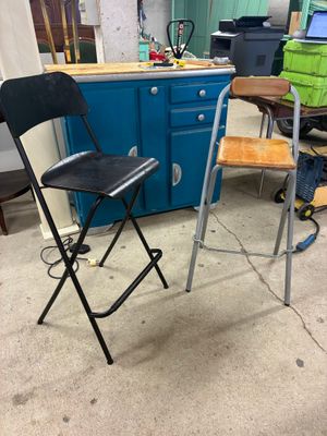 two chairs and a table in a room with a blue cabinet