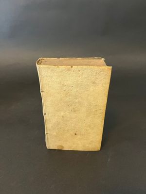 an old book sitting on top of a table next to a black background