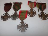 four medals and a cross on a white surface