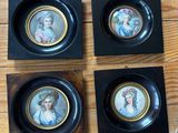 quatre portraits miniatures de femmes, encadrés dans des cadres noirs, posés sur un plancher en bois