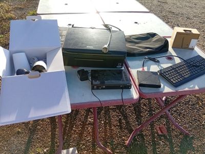 a table with a laptop, keyboard, and other items on it
