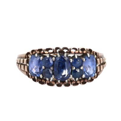 un gros plan d'une bague à trois pierres sur fond blanc