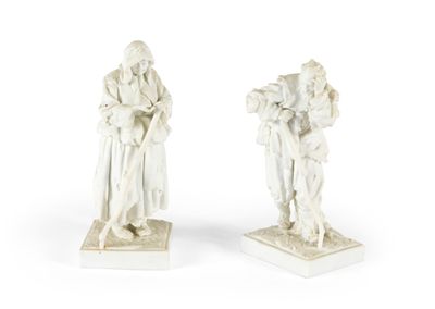 deux statues blanches représentant un homme et une femme tenant un enfant dans leurs bras