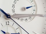 a close up of a white watch with a blue second hand
