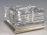 a silver and clear glass ashtray on a metal stand