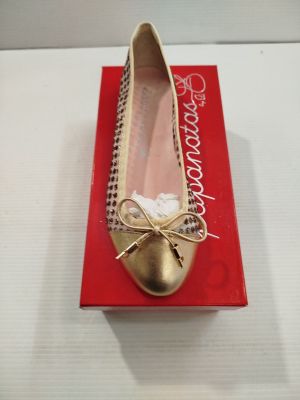 Quelqu'un porte une paire de chaussures dorées ornées de nœuds.