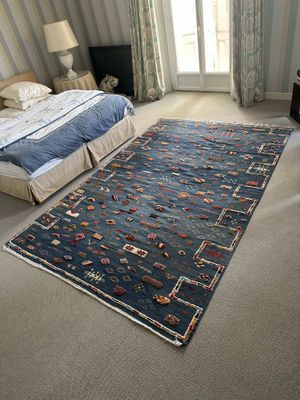 a bedroom with a bed and a rug on the floor