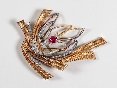 une image représentant une broche en or et diamants ornée d'une pierre rouge