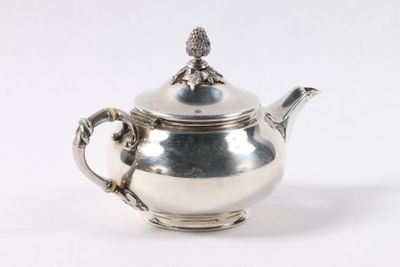 une théière en argent avec un oiseau sur le couvercle