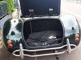 a black car with a trunk open on the side of the road