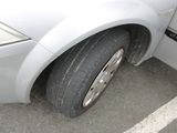 a close up of a car ' s tire on the side of the road