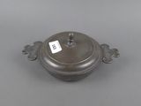 an old metal pot with a tag on it sitting on a table