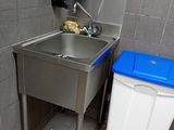 a sink and trash can in a public restroom