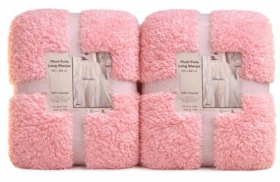 quatre serviettes roses empilées les unes sur les autres sur une surface blanche