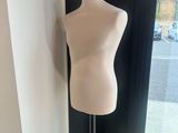 le mannequin est assis sur un socle devant une vitrine