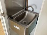 un évier en acier inoxydable dans le coin d'une salle de bains