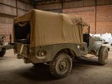 two military vehicles parked in a warehouse with a tarp covering on the back