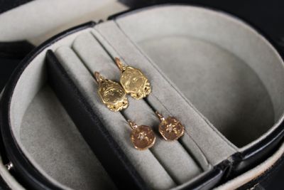 une paire de boucles d'oreilles dans un écrin posé sur une table