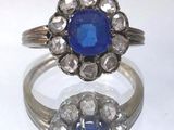 une image d'une bague avec une pierre bleue entourée de diamants