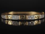 gros plan d'une bague en or et diamants sur une surface noire
