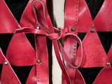 a close up of a red and black vest with a bow