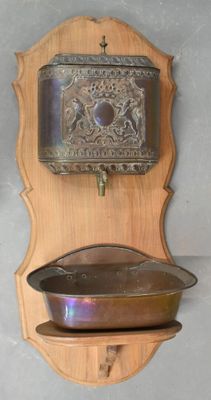 a wooden wall mounted with a metal pan on it